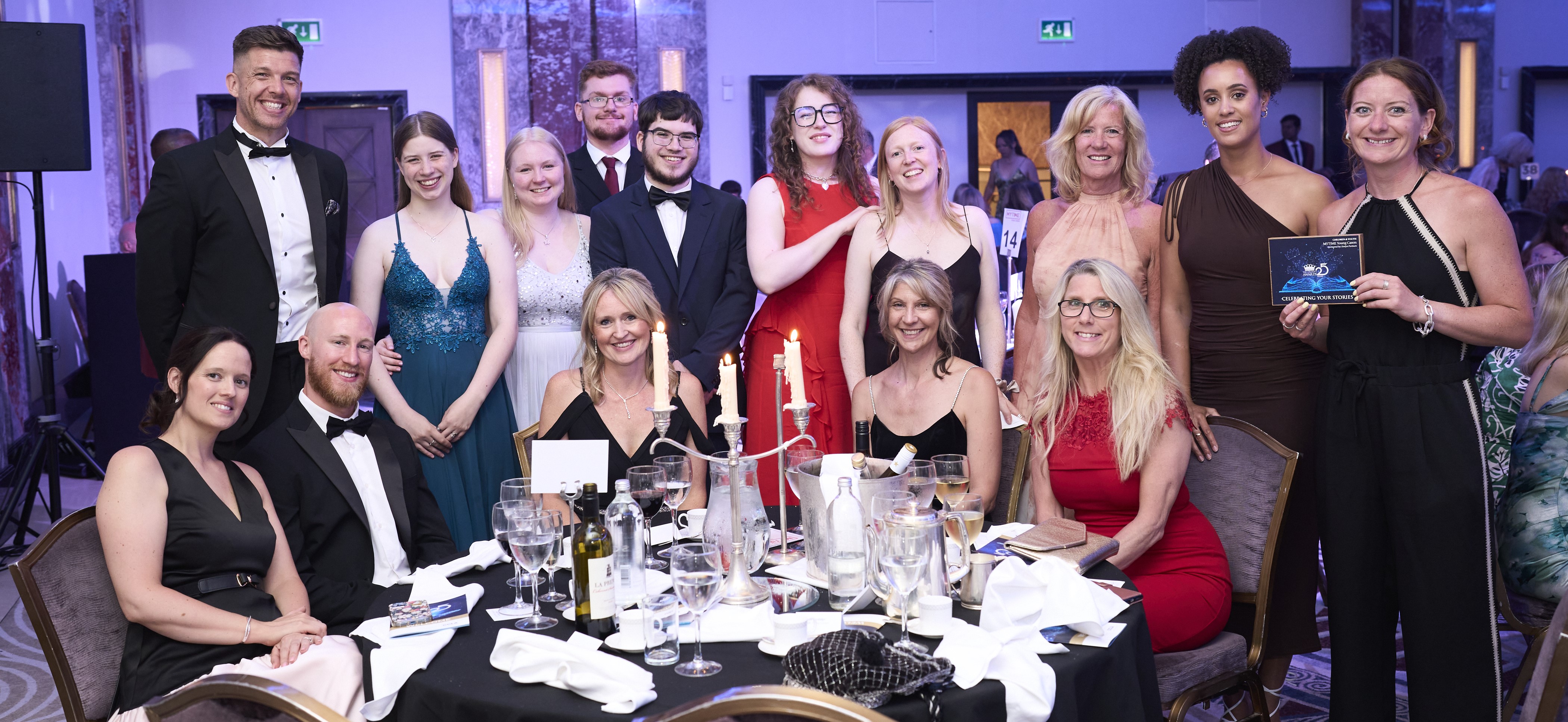 MYTIME Young Carers team celebrating their Charity Awards 2025 win at the Royal Lancaster Hotel, pictured at the ceremony dinner table with their trophy.